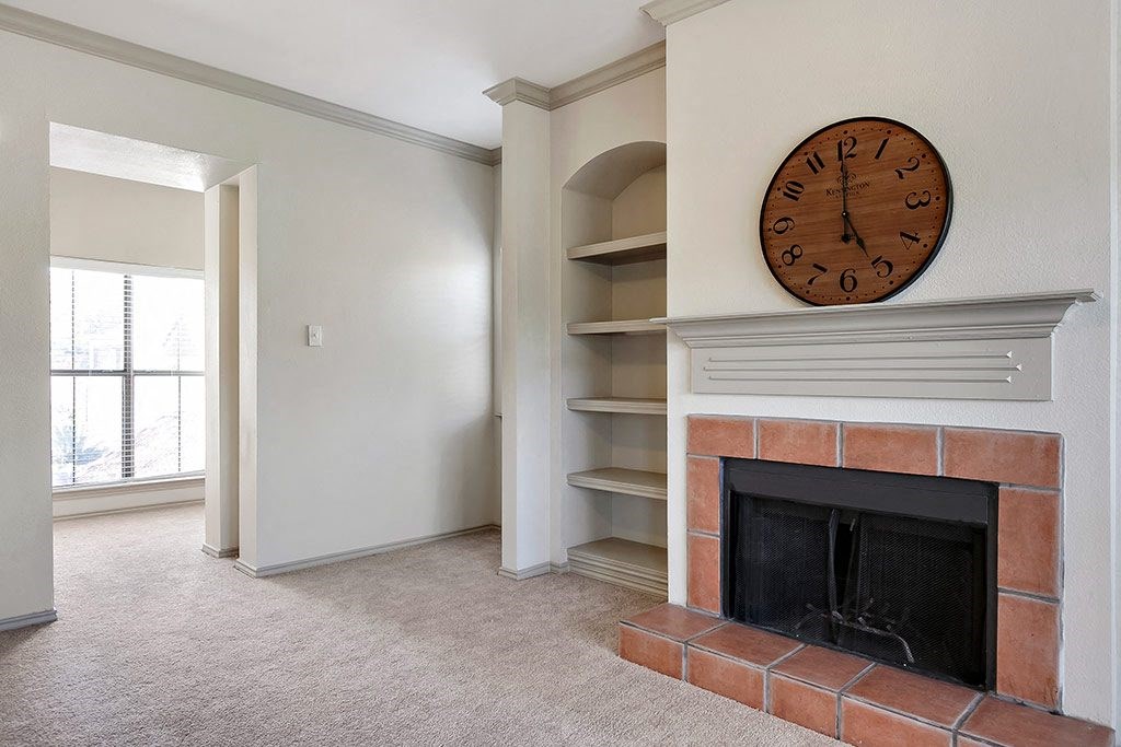 a living room with a fireplace and a clock on the wall