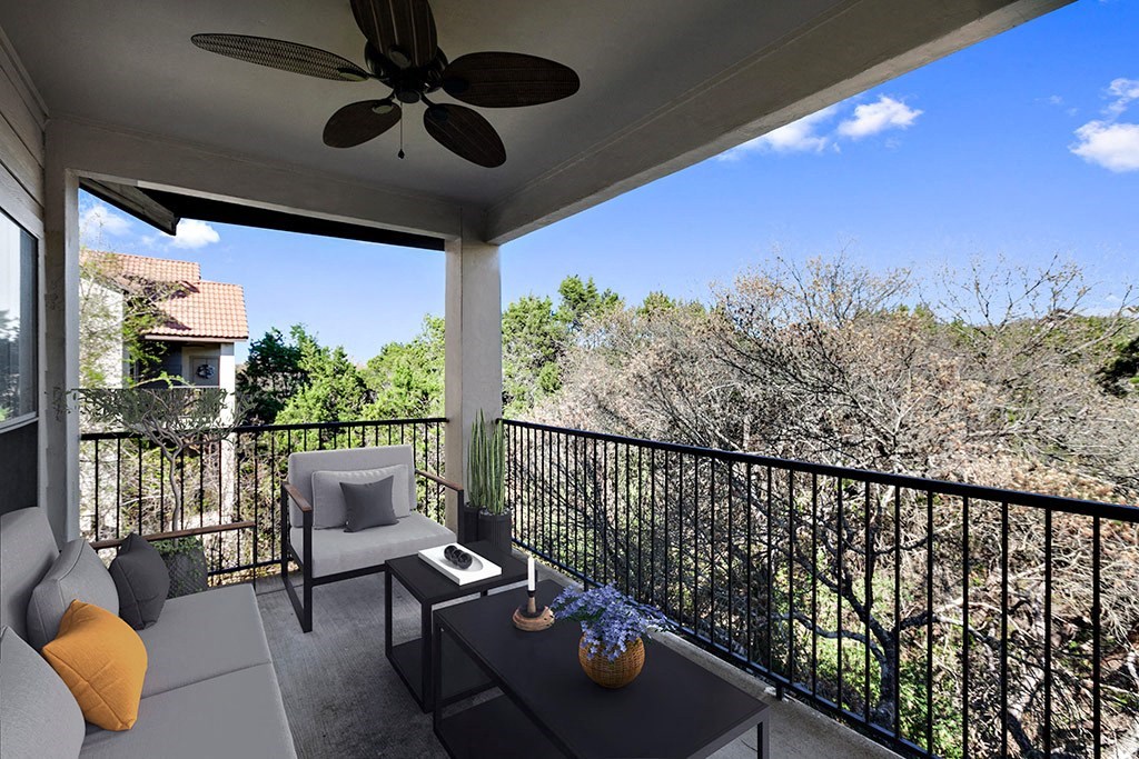 a covered patio with a ceiling fan and chairs