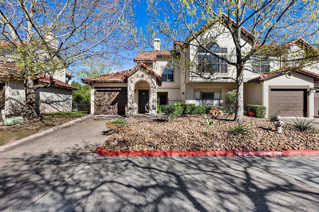 a house with a driveway and a fire hydrant in front of it