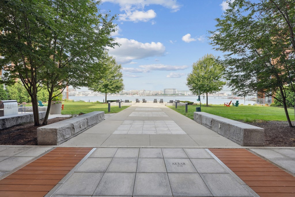 A walkway with trees on either side leading to a distant building.