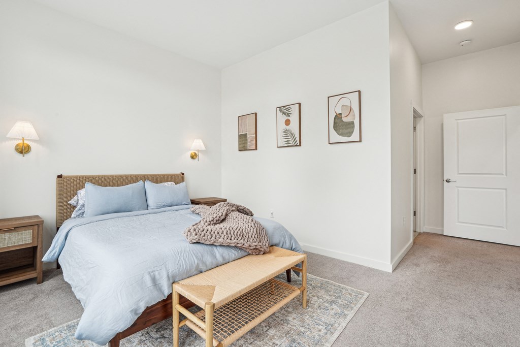 a bedroom with a bed and a wooden bench