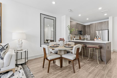 A modern dining room with a wooden table and chairs.