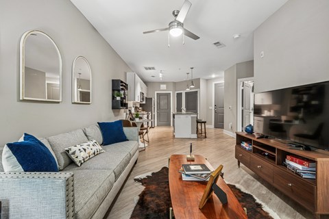 A living room with a grey couch and a wooden coffee table.