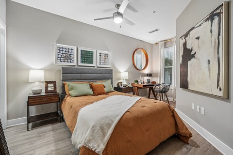 A bedroom with a large bed and a ceiling fan.