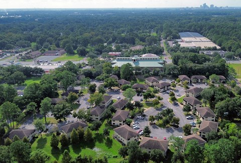 A bird's eye view of a residential area with houses and a large green space.