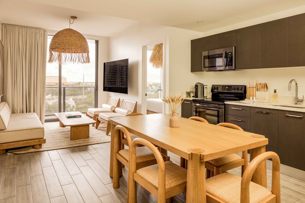 A modern kitchen with a wooden table and chairs.