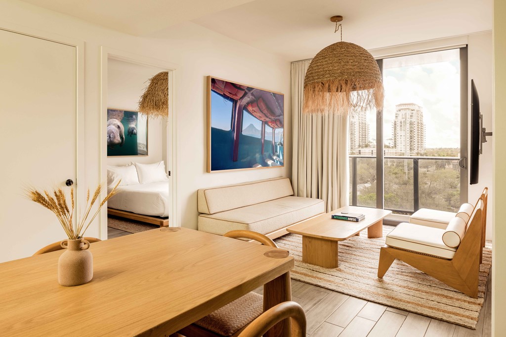 A living room with a couch, a chair, a table, and a painting on the wall.