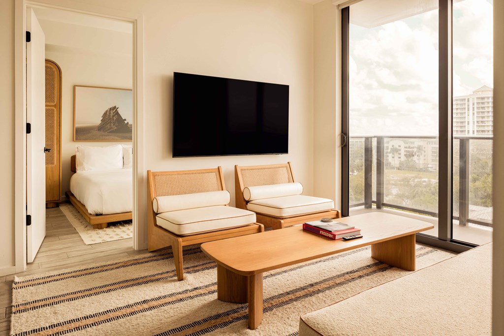 A living room with a flat screen TV mounted on the wall.