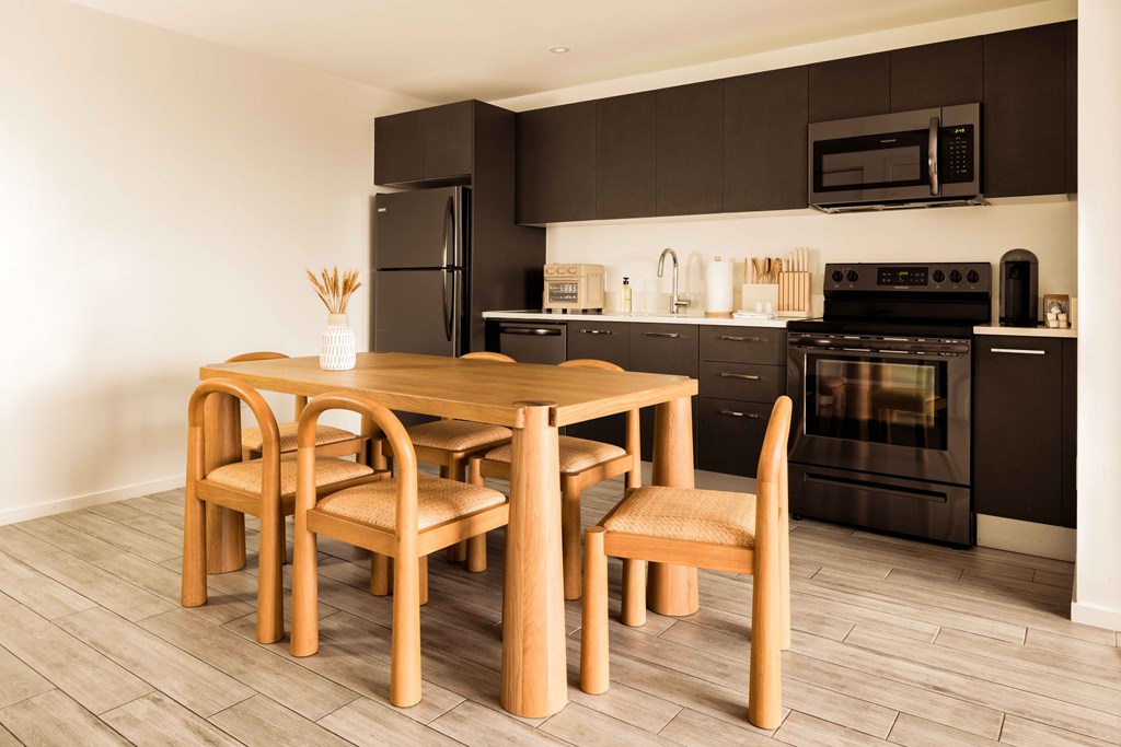 A modern kitchen with a wooden dining table and chairs.