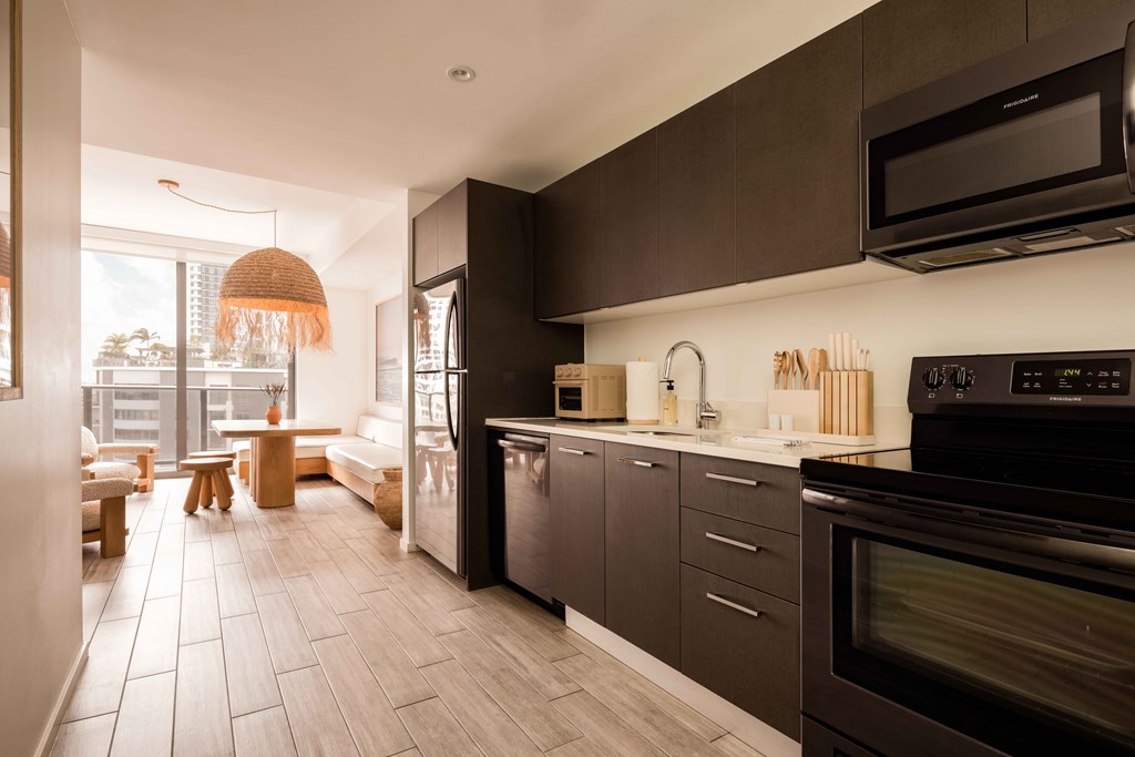 A modern kitchen with dark brown cabinets and a black oven.