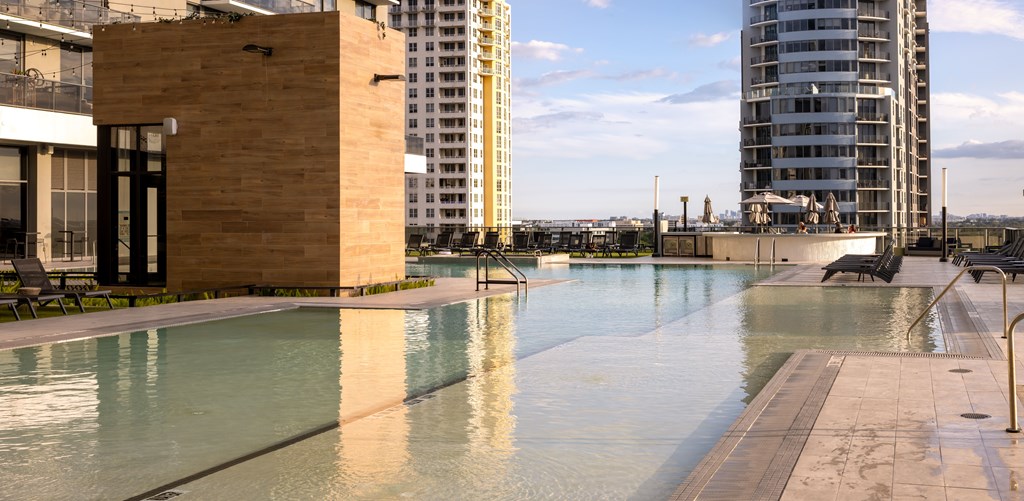 A pool in a city setting with a tall building in the background.