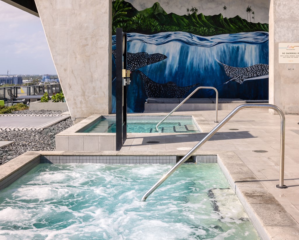A hot tub with a mural of a shark in the background.