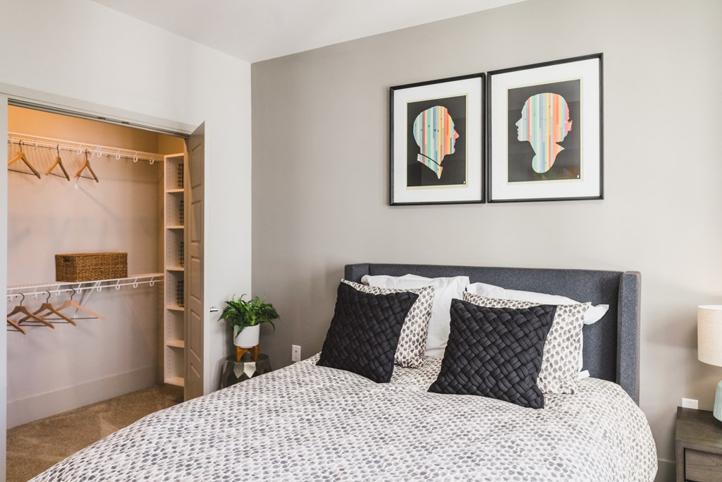 a bedroom with a bed and two paintings on the wall