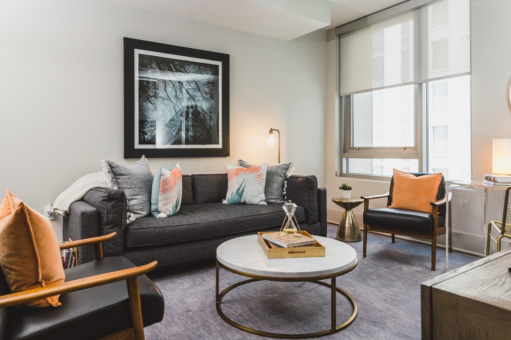 a living room with a black couch and a white coffee table