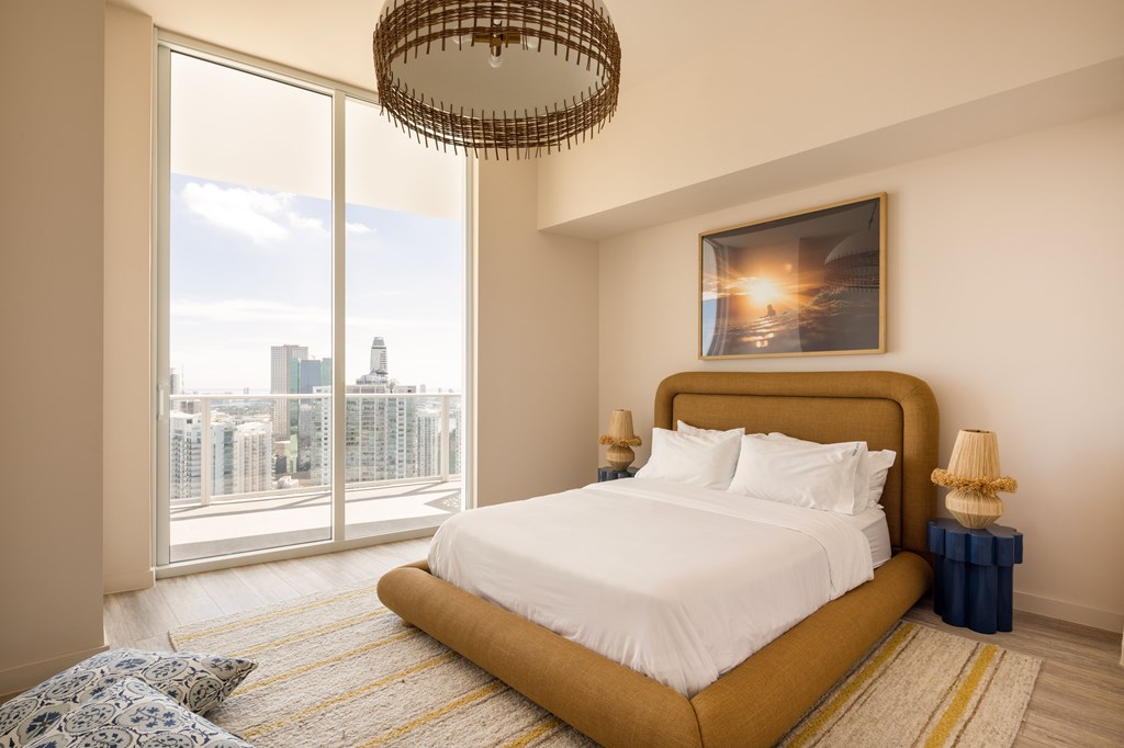 A bedroom with a large bed and a view of the city.