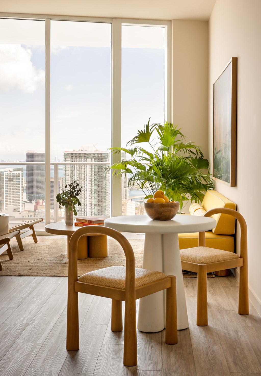 A dining room with a table, chairs and a view of the city.