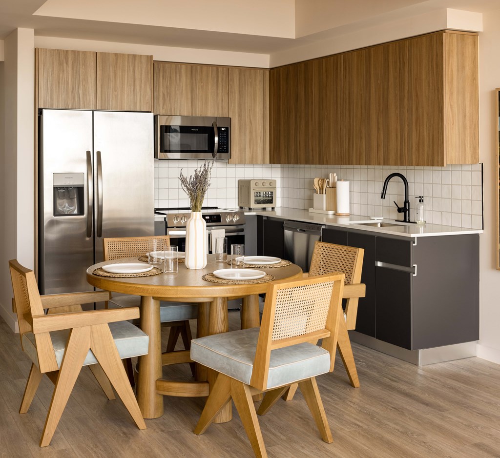 A modern kitchen with a round table set for four.