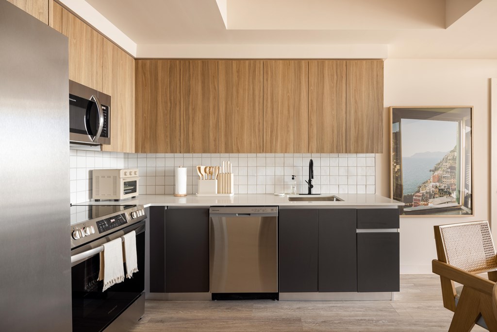 A modern kitchen with wooden cabinets and stainless steel appliances.