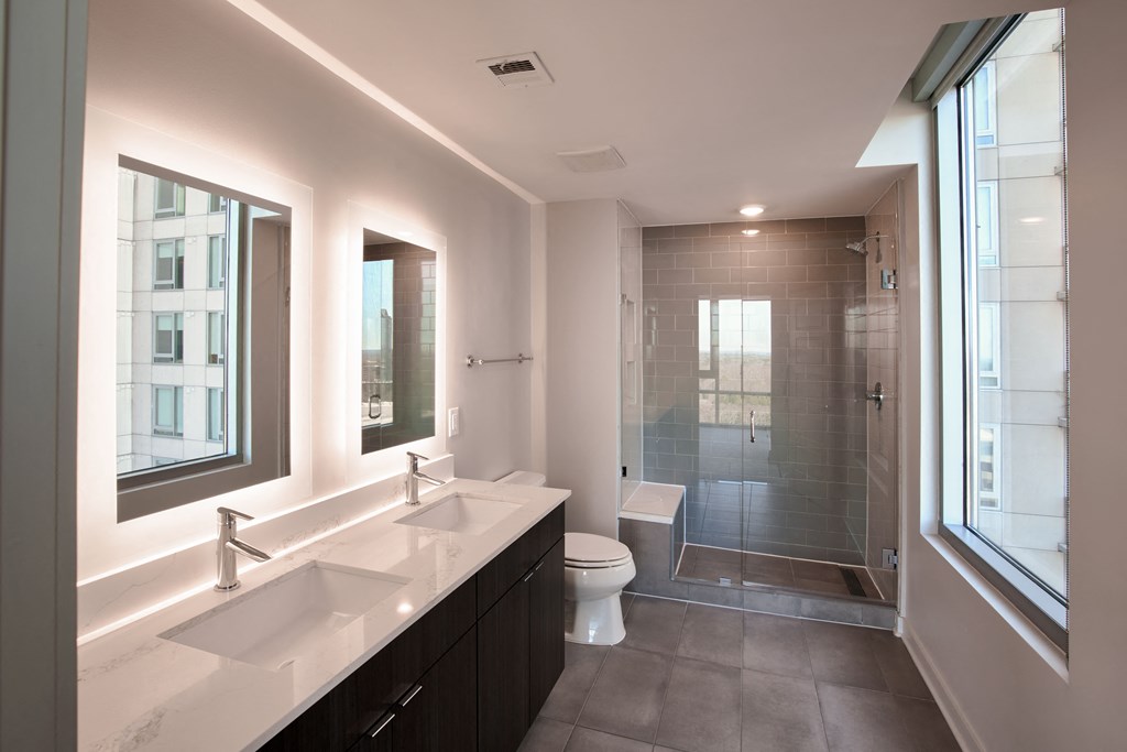 a bathroom with two sinks and a shower and a toilet