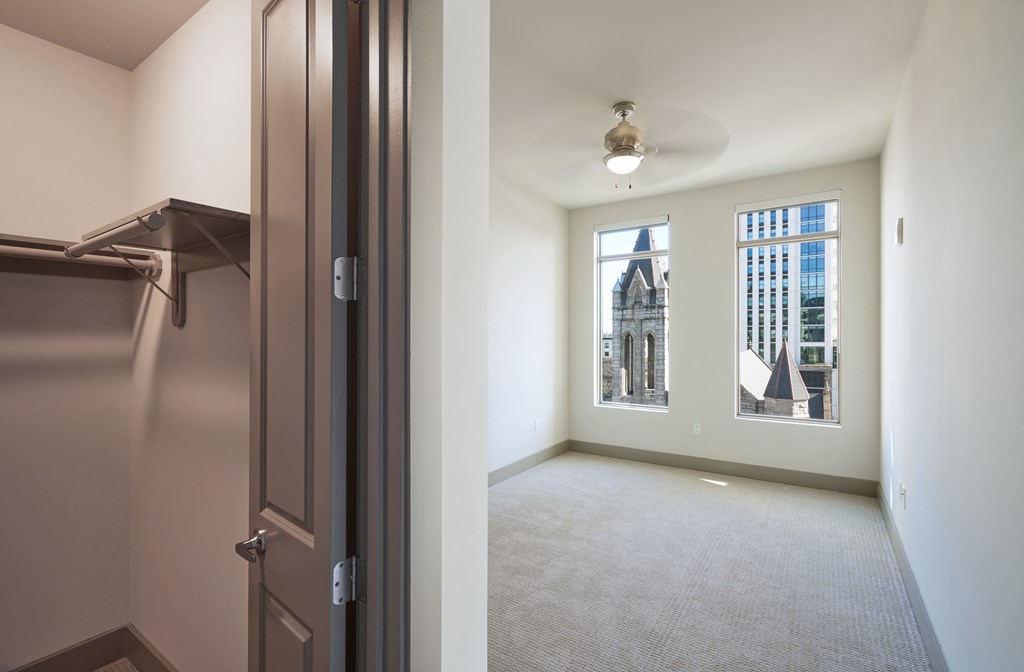 an empty living room with a closet and a window