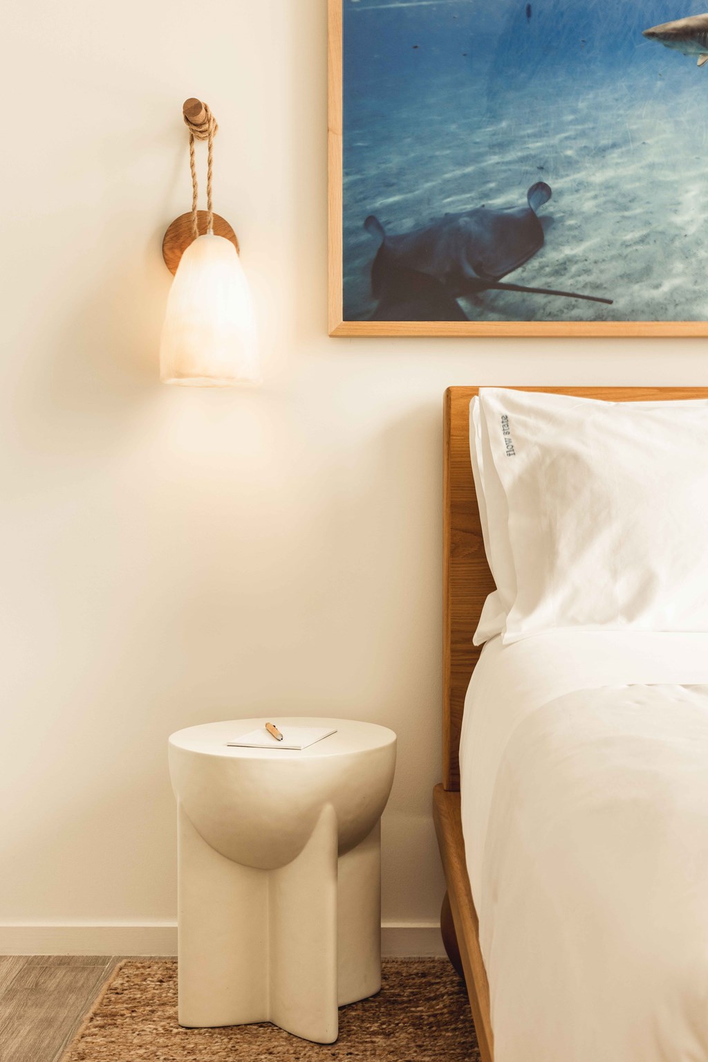 A white toilet with a wooden frame and a painting of a cow in the background.