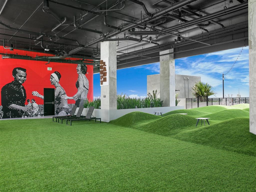 a room with grass and a mural of people on it