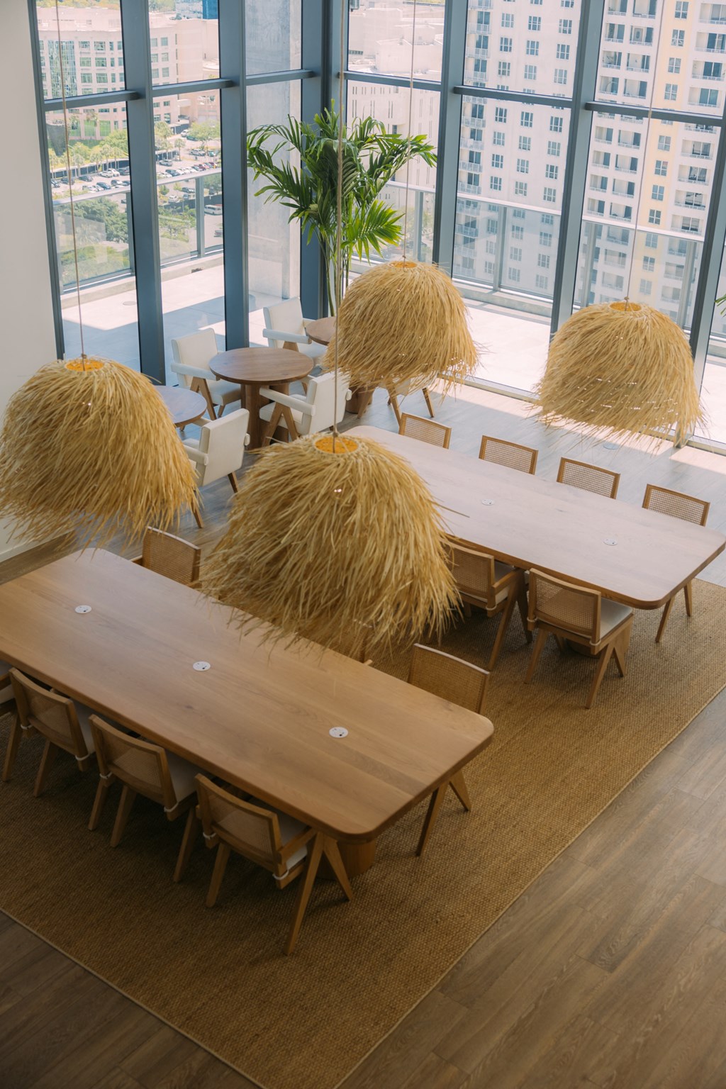 a group of tables with hay on them in a room with large windows