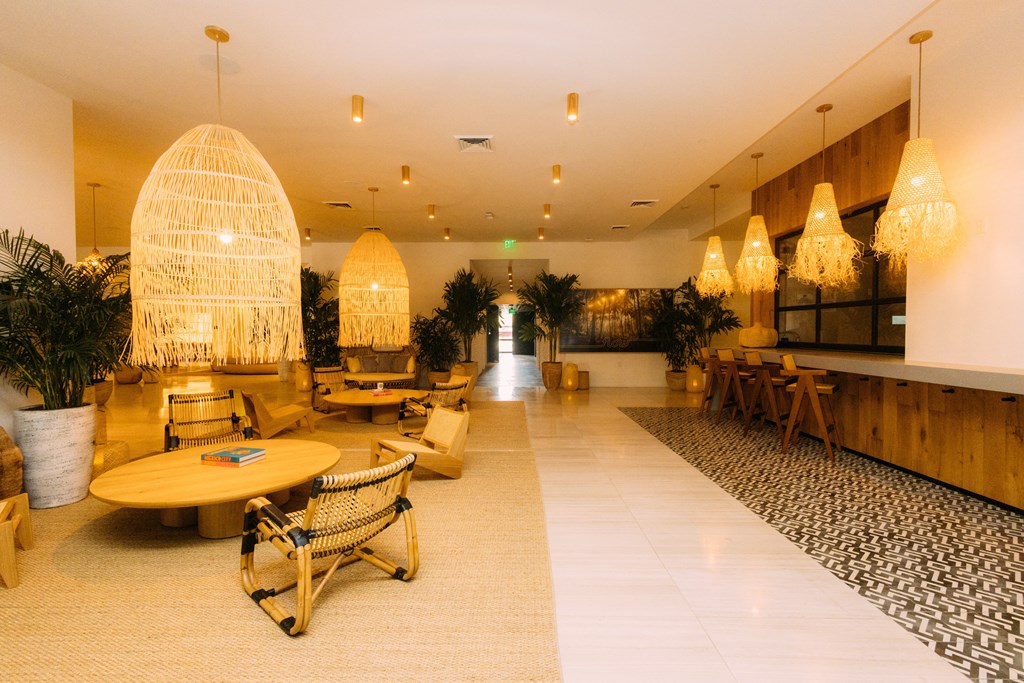 the lobby of a hotel with tables and chairs and chandeliers