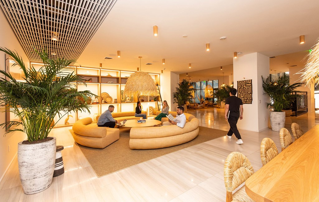 the lobby of a hotel with people sitting in couches