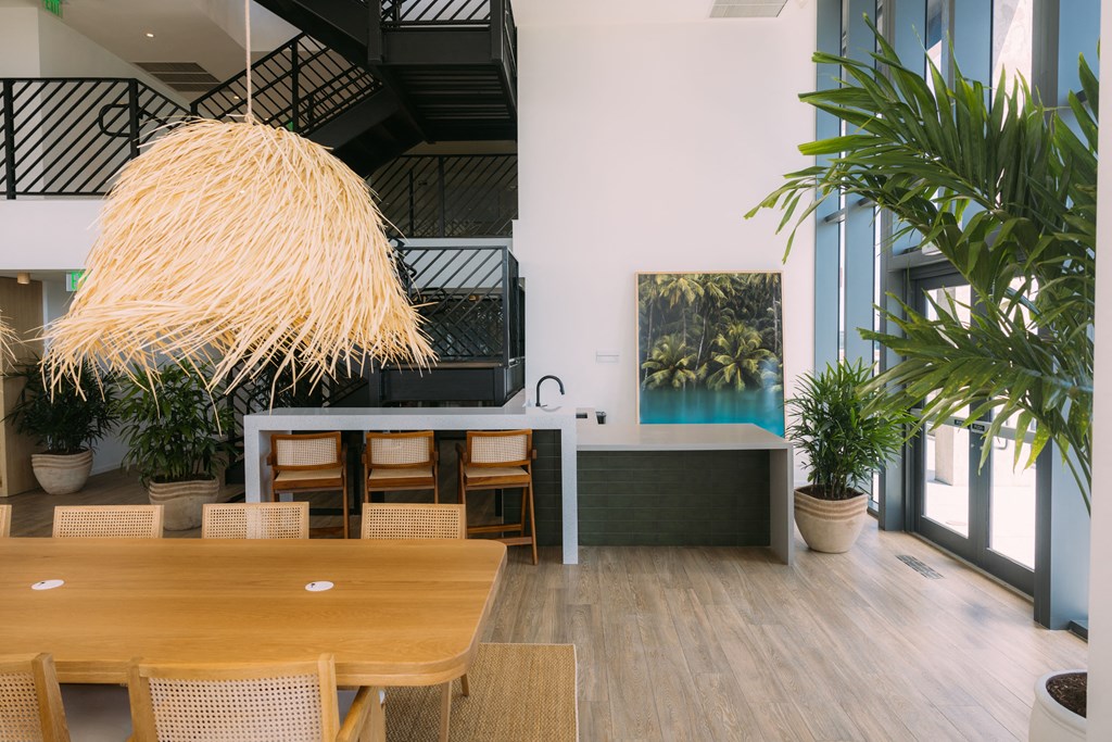 a dining area with a wooden table and chairs and a kitchen with a large window
