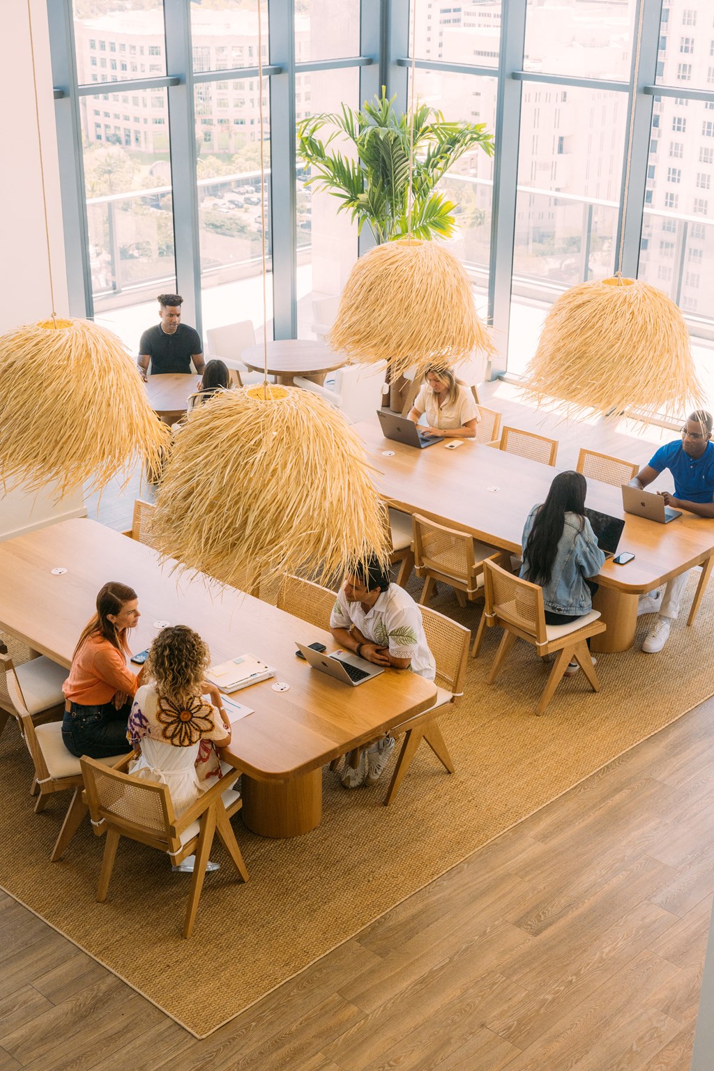 people sitting at tables with hay pails in an office