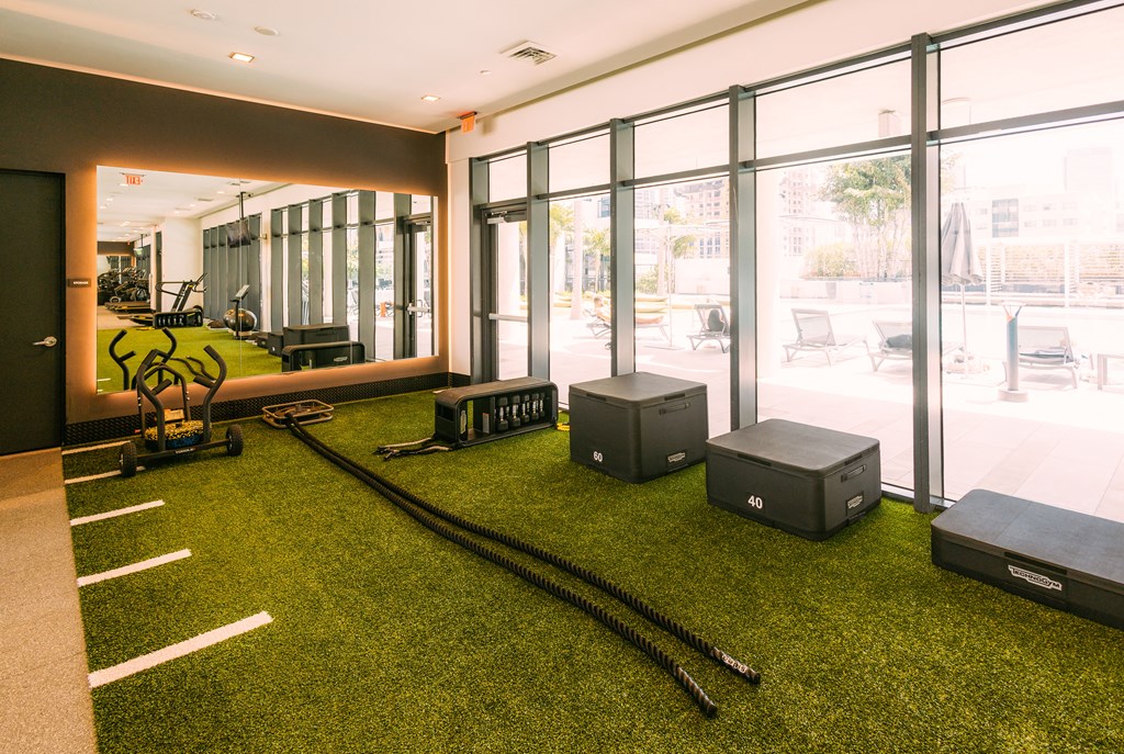 a workout room with weights and cardio equipment on the grass