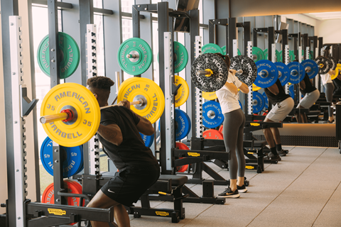 a group of people lifting weights in a gym