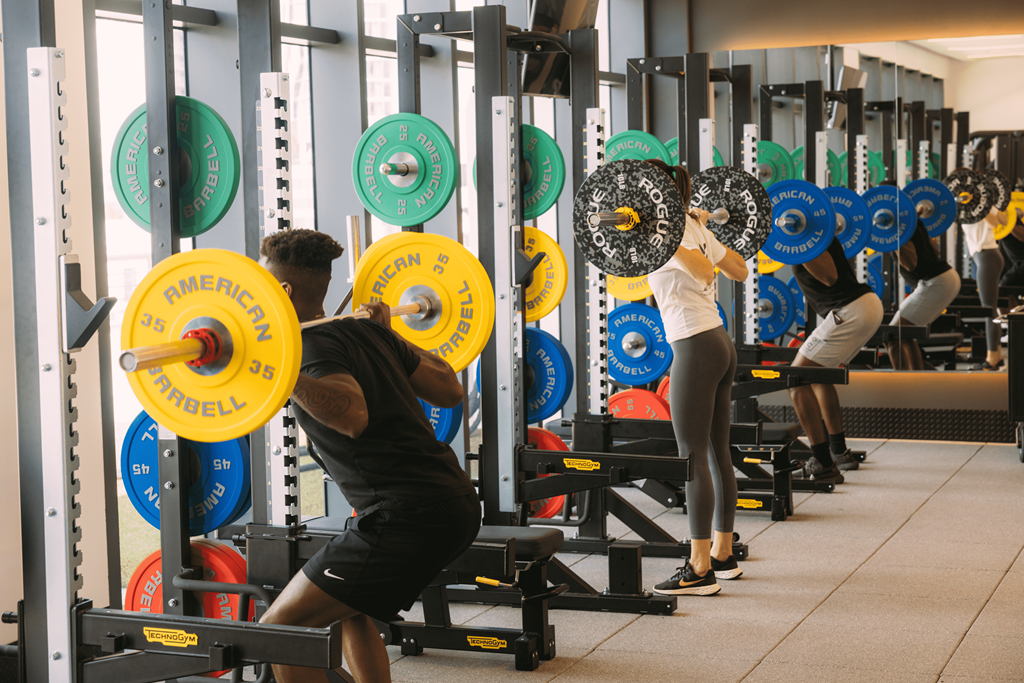 a group of people lifting weights in a gym