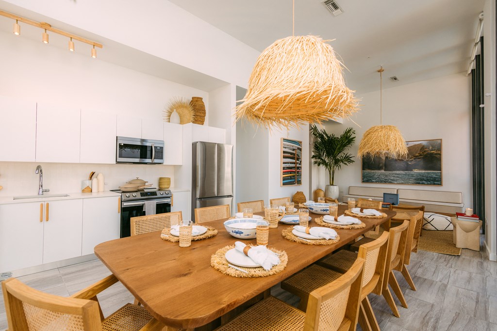 a dining room with a wooden table and chairs and a kitchen