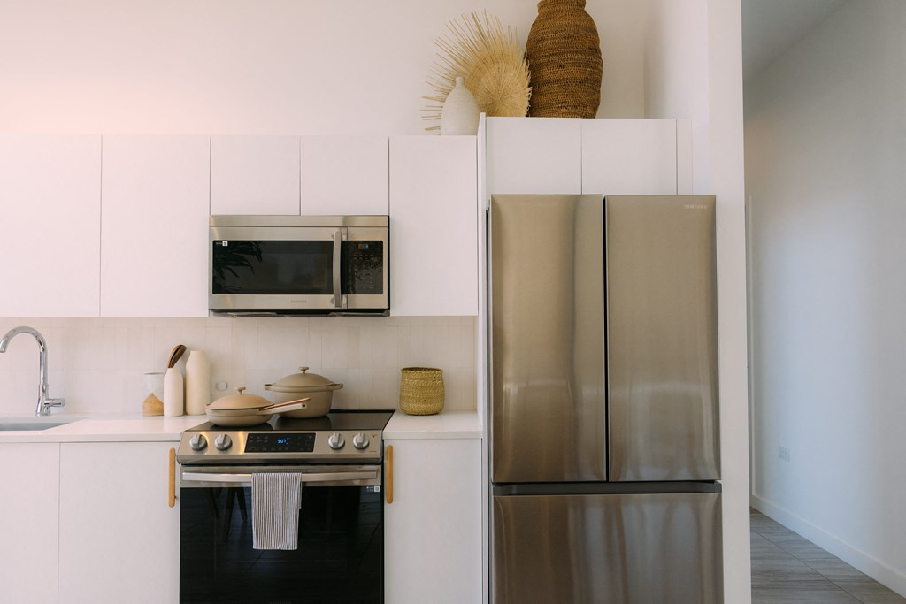 a kitchen with stainless steel appliances and white cabinets