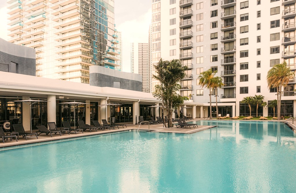 a large swimming pool with tall buildings in the background