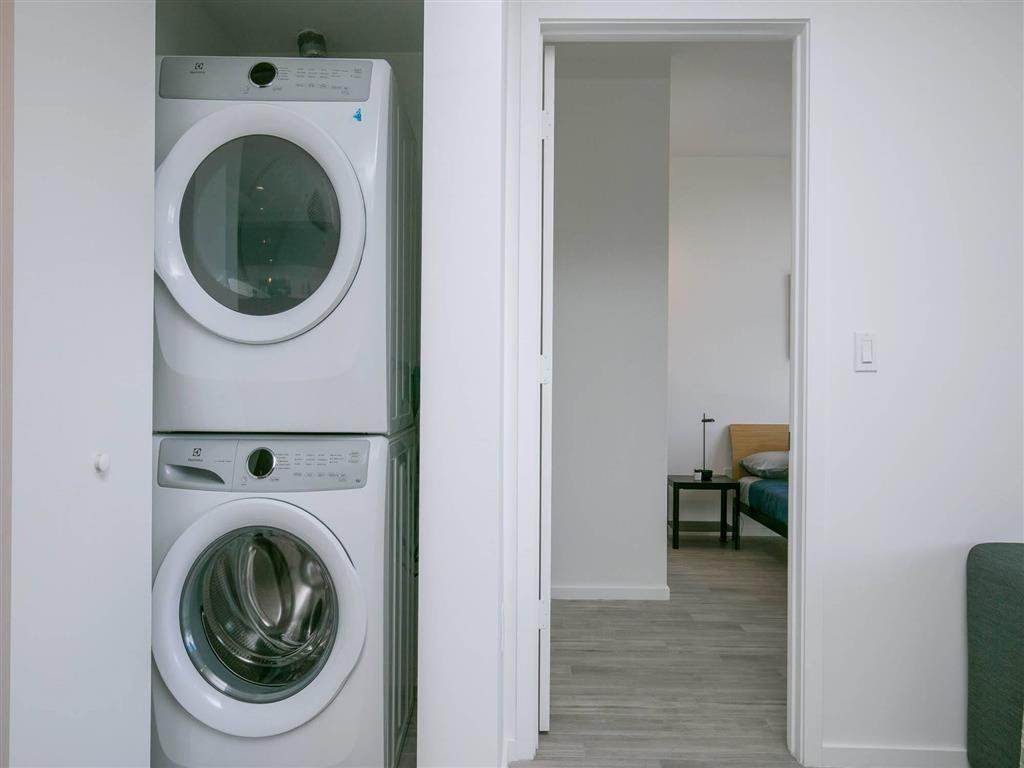 A white washing machine and dryer in a small room.