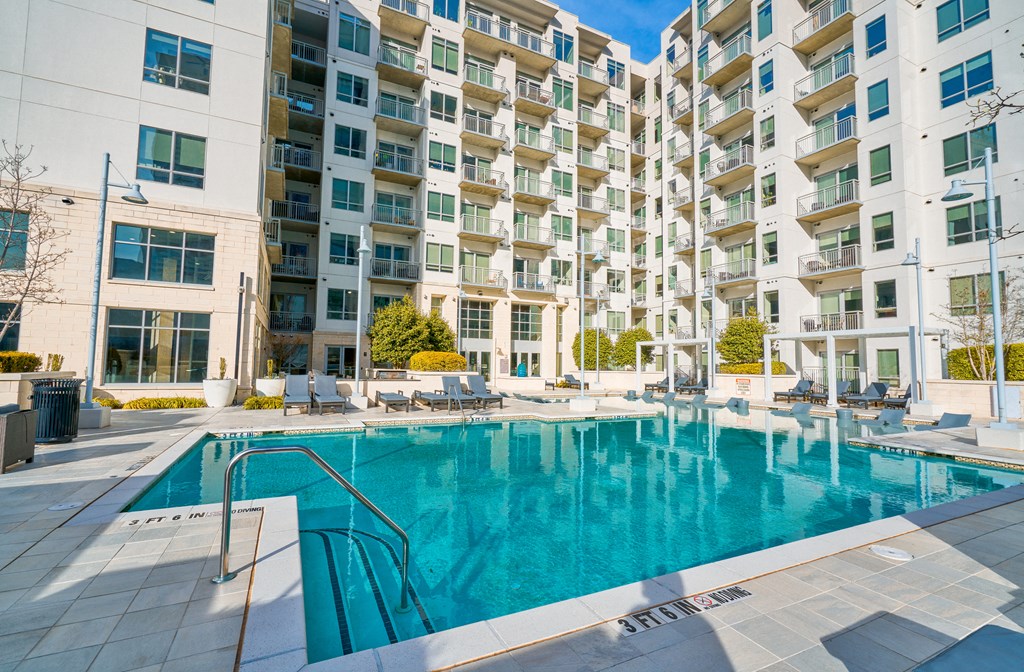 a swimming pool with an apartment building in the background
