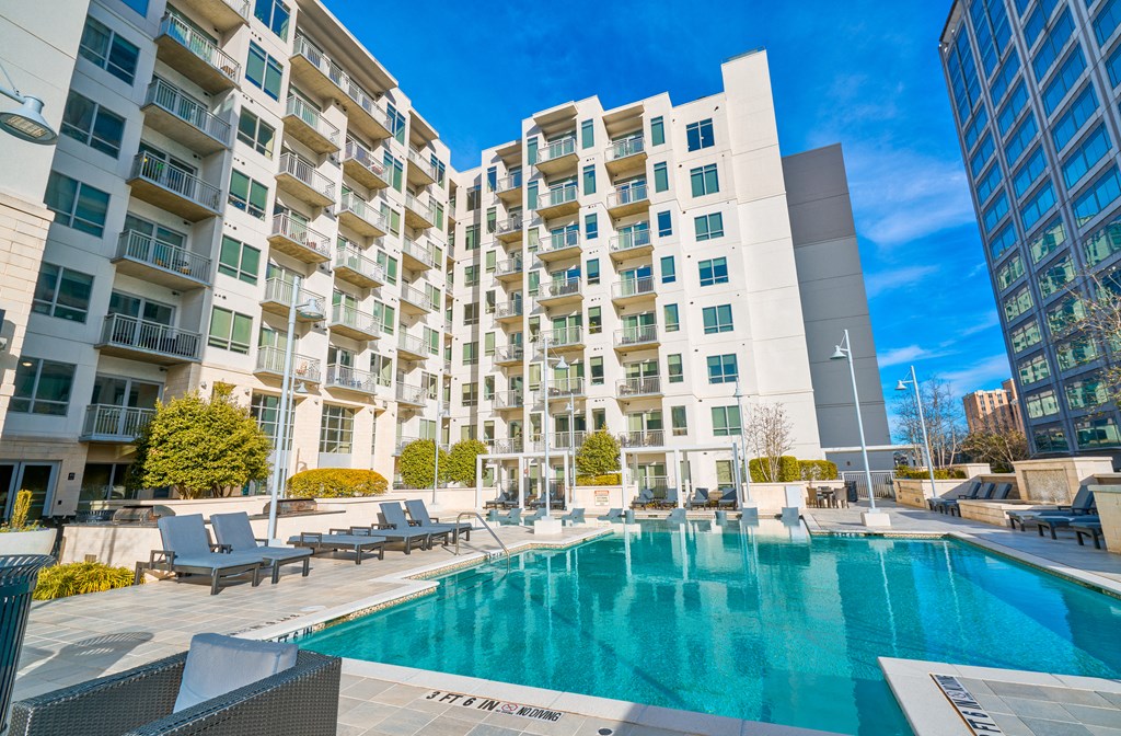 a swimming pool with an apartment building in the background