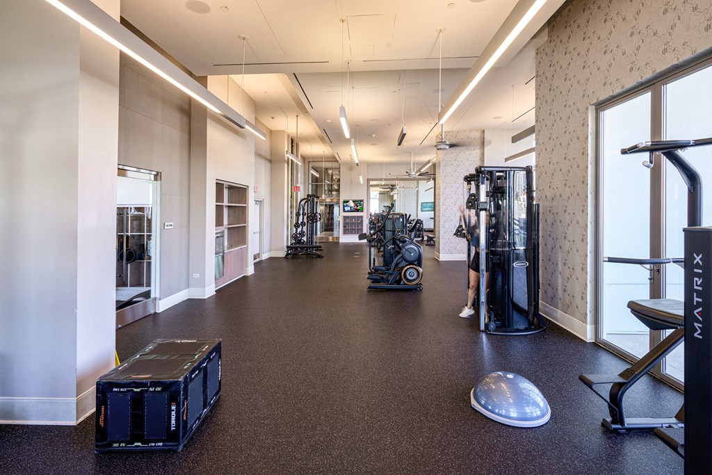 a workout room with weights and cardio equipment in a building