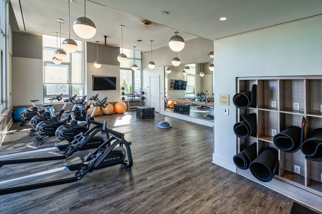 a gym with weights machines and a kitchen in the background