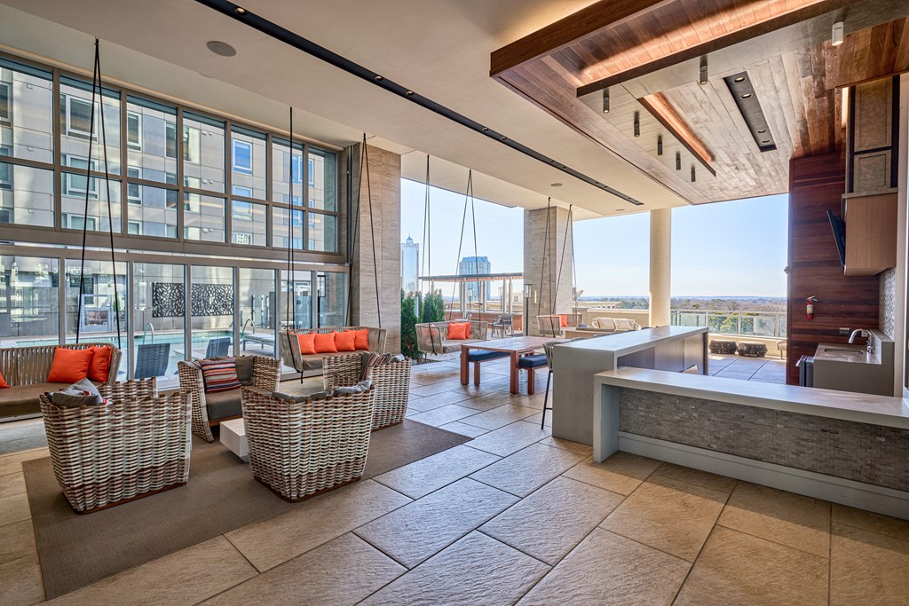 a lobby of a building with large windows and a table and chairs