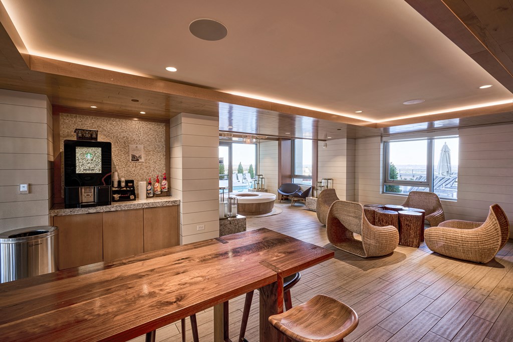 a living room with a wooden table and chairs and a kitchen