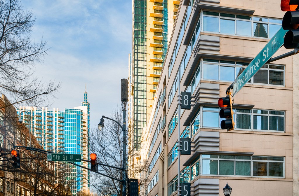 a city street with street signs and traffic lights in front of tall buildings