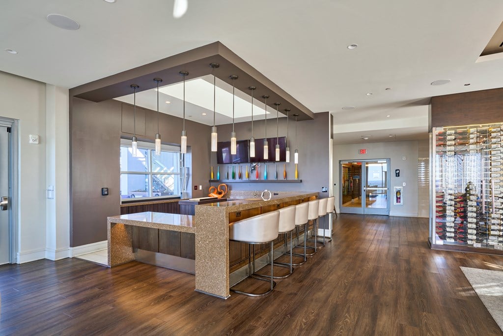 a kitchen with a long counter and a row of chairs