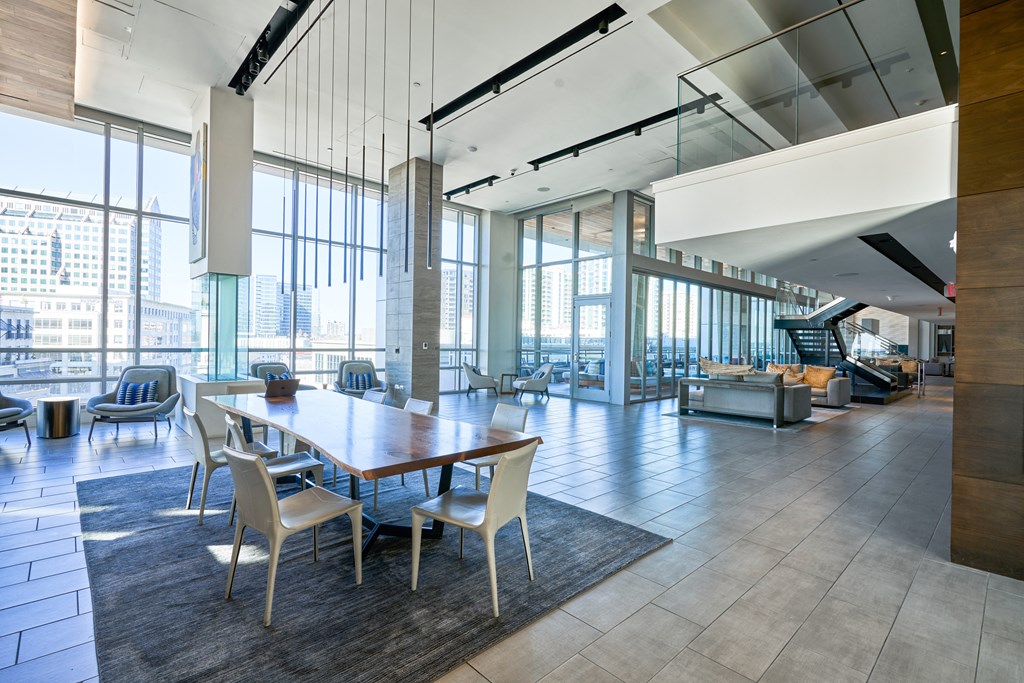 a dining room with a table and chairs in a building with large windows