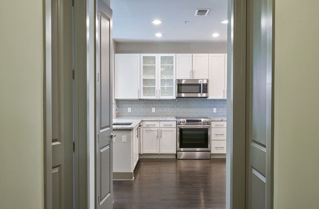 a view through a doorway of a kitchen with white cabinets