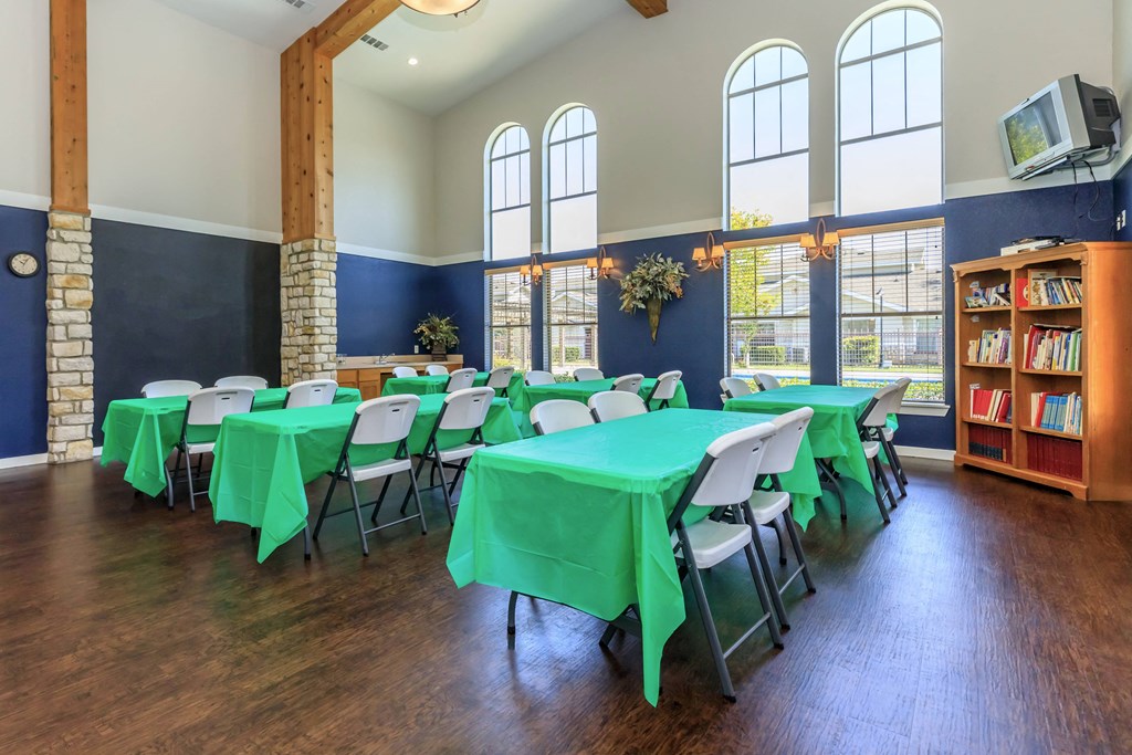 a conference room with green table cloths and white chairs