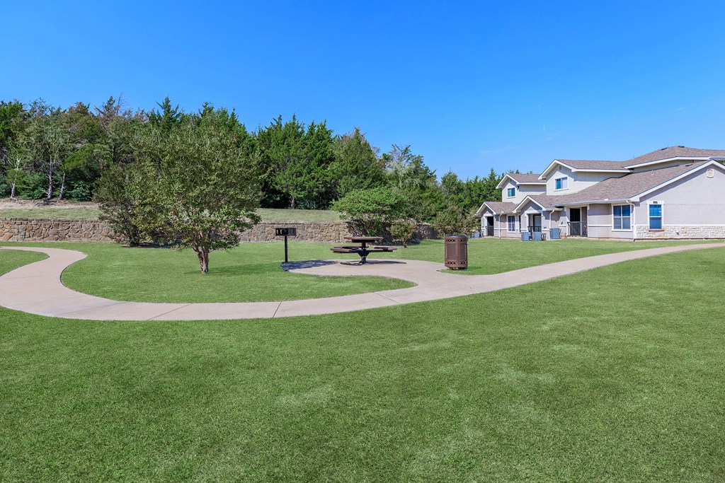 a yard with a picnic table in front of a house